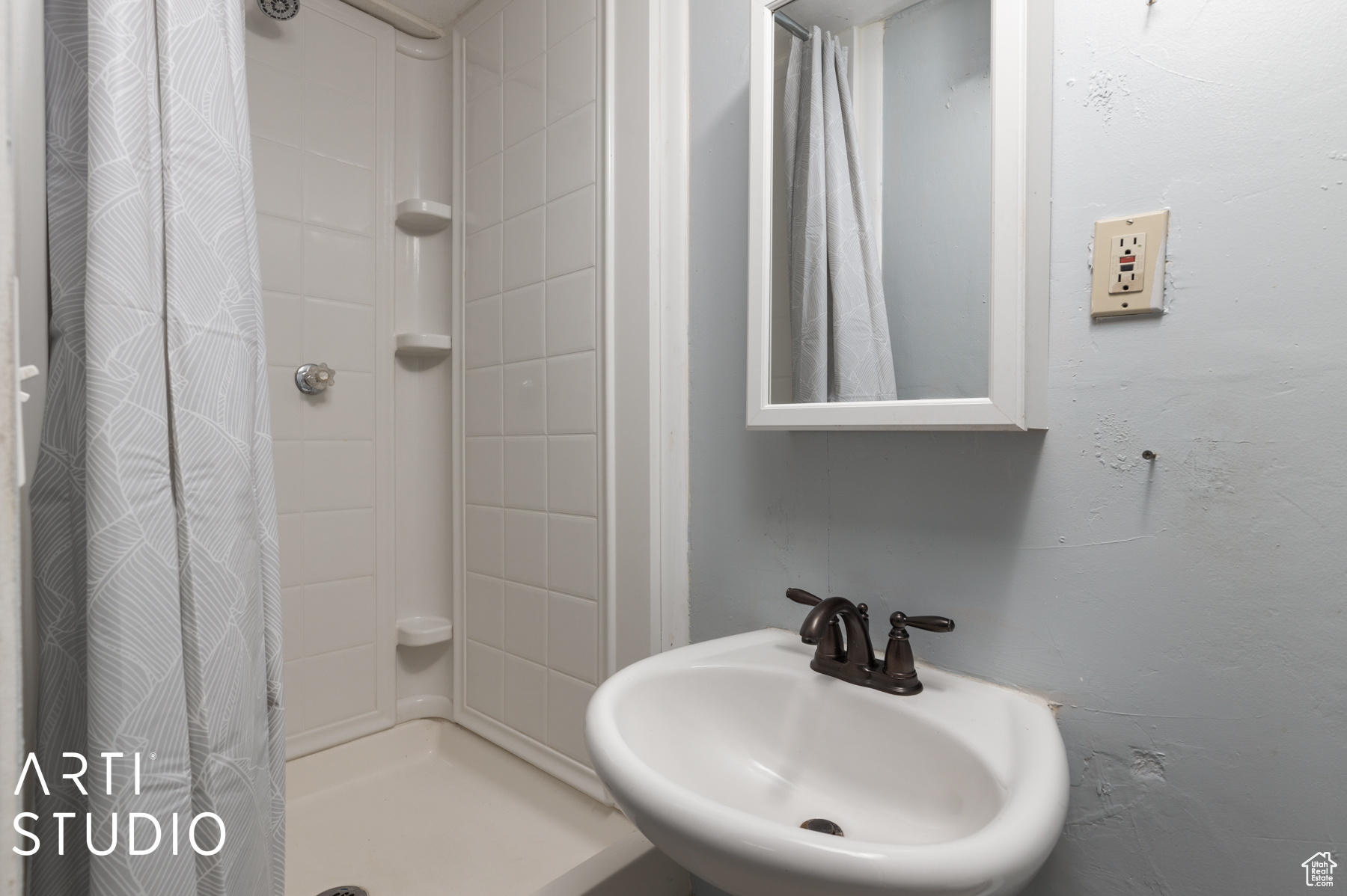 Bathroom featuring curtained shower and sink