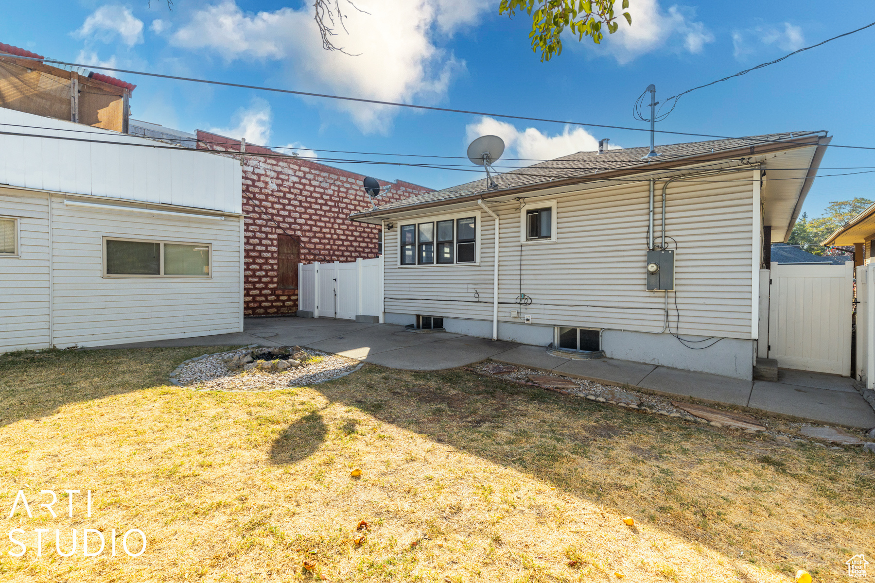 Rear view of property featuring a lawn and a patio