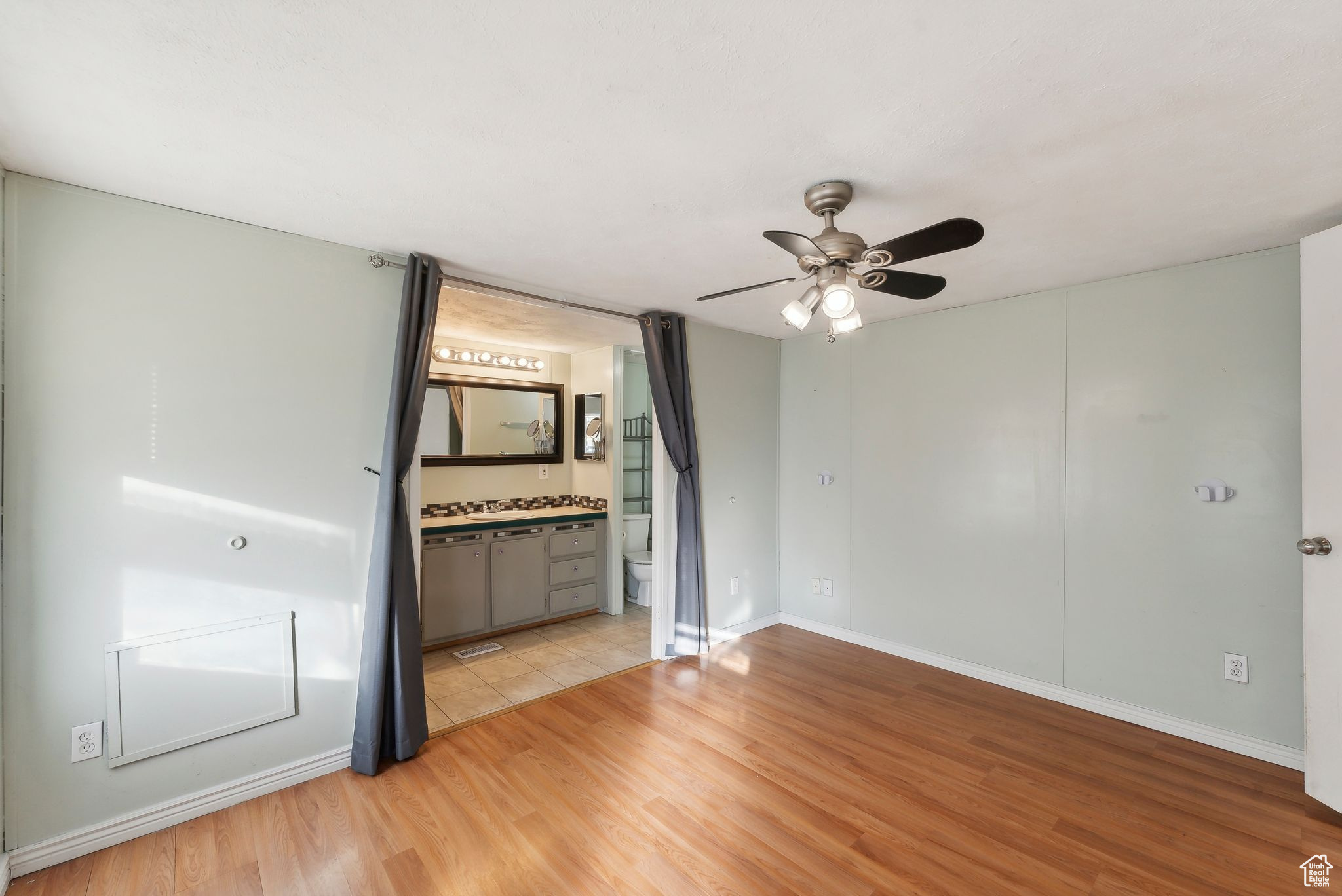 Empty room featuring ceiling fan and light hardwood / wood-style floors