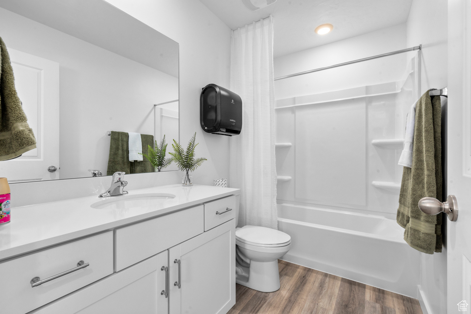 Full bathroom with toilet, hardwood / wood-style floors, vanity, and shower / tub combo with curtain