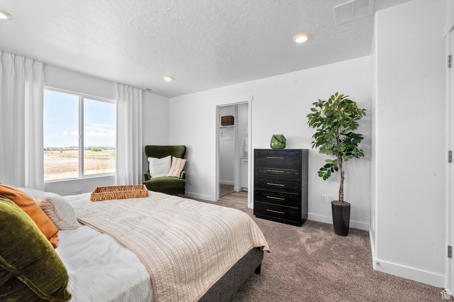 Bedroom featuring carpet flooring, a textured ceiling, and ensuite bathroom