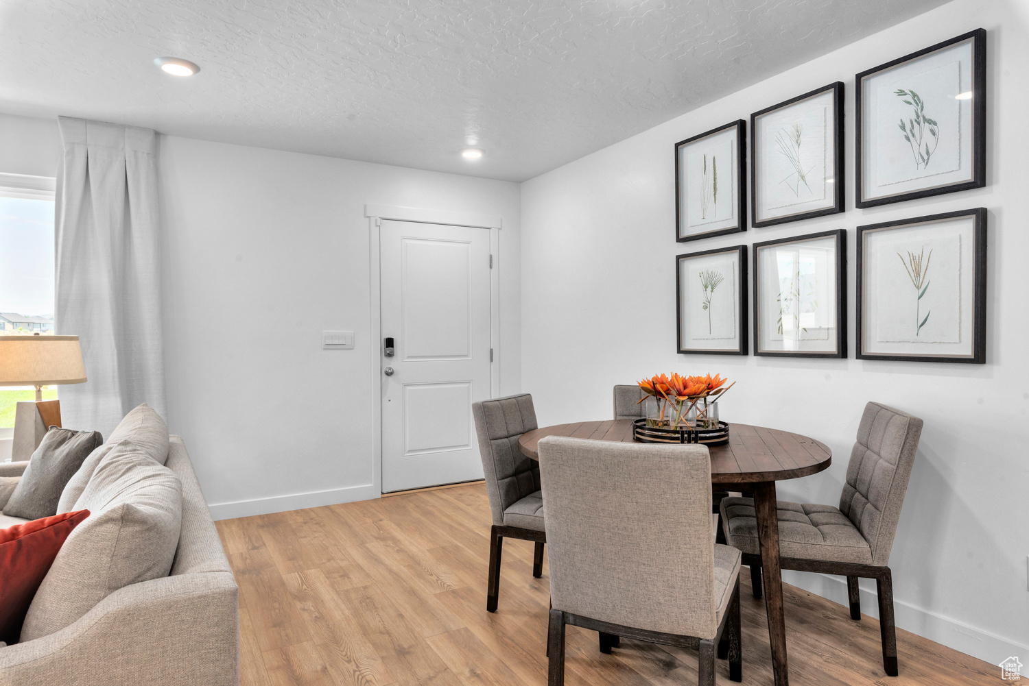 Dining room with light hardwood / wood-style flooring and a textured ceiling