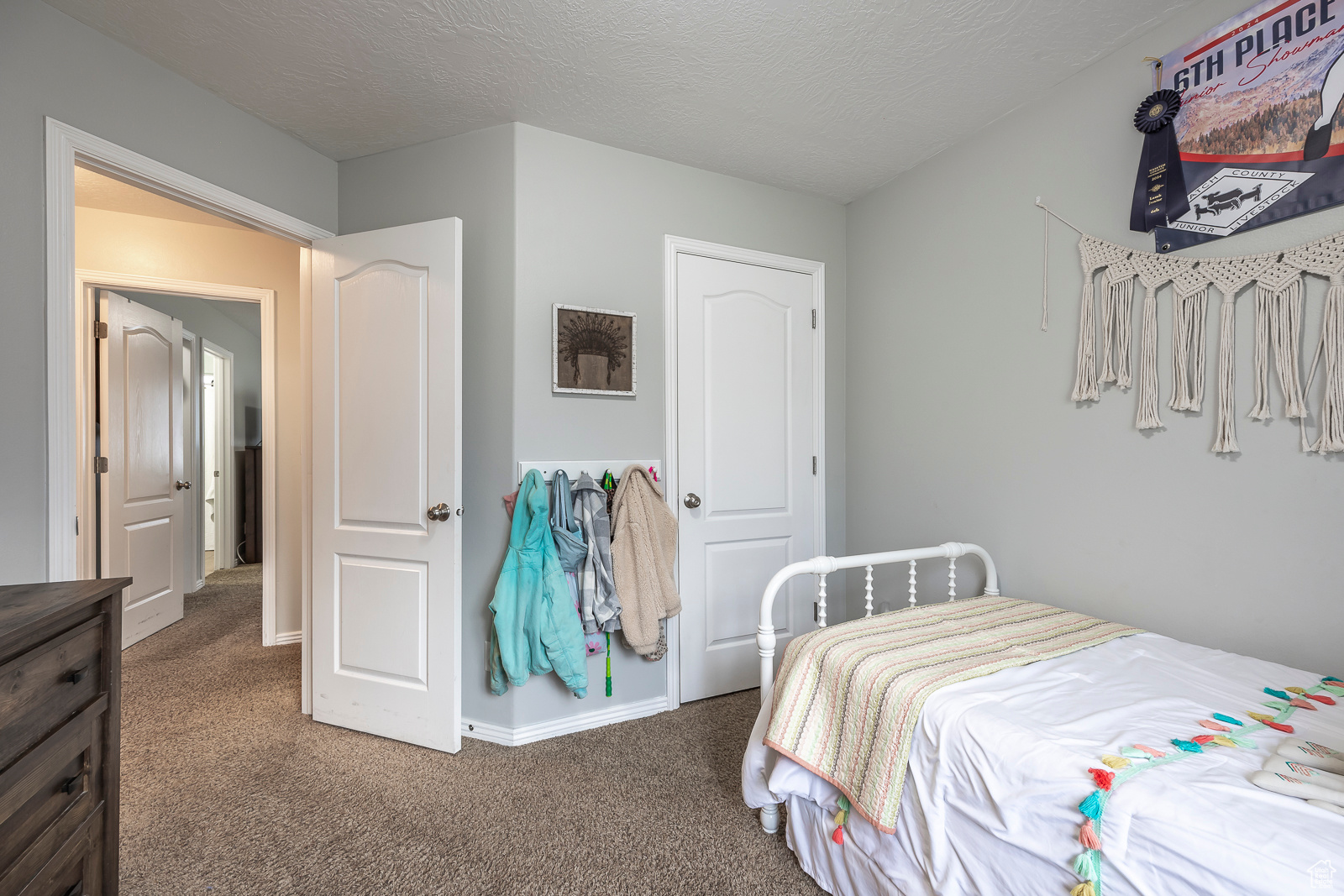 Bedroom with a textured ceiling and dark colored carpet