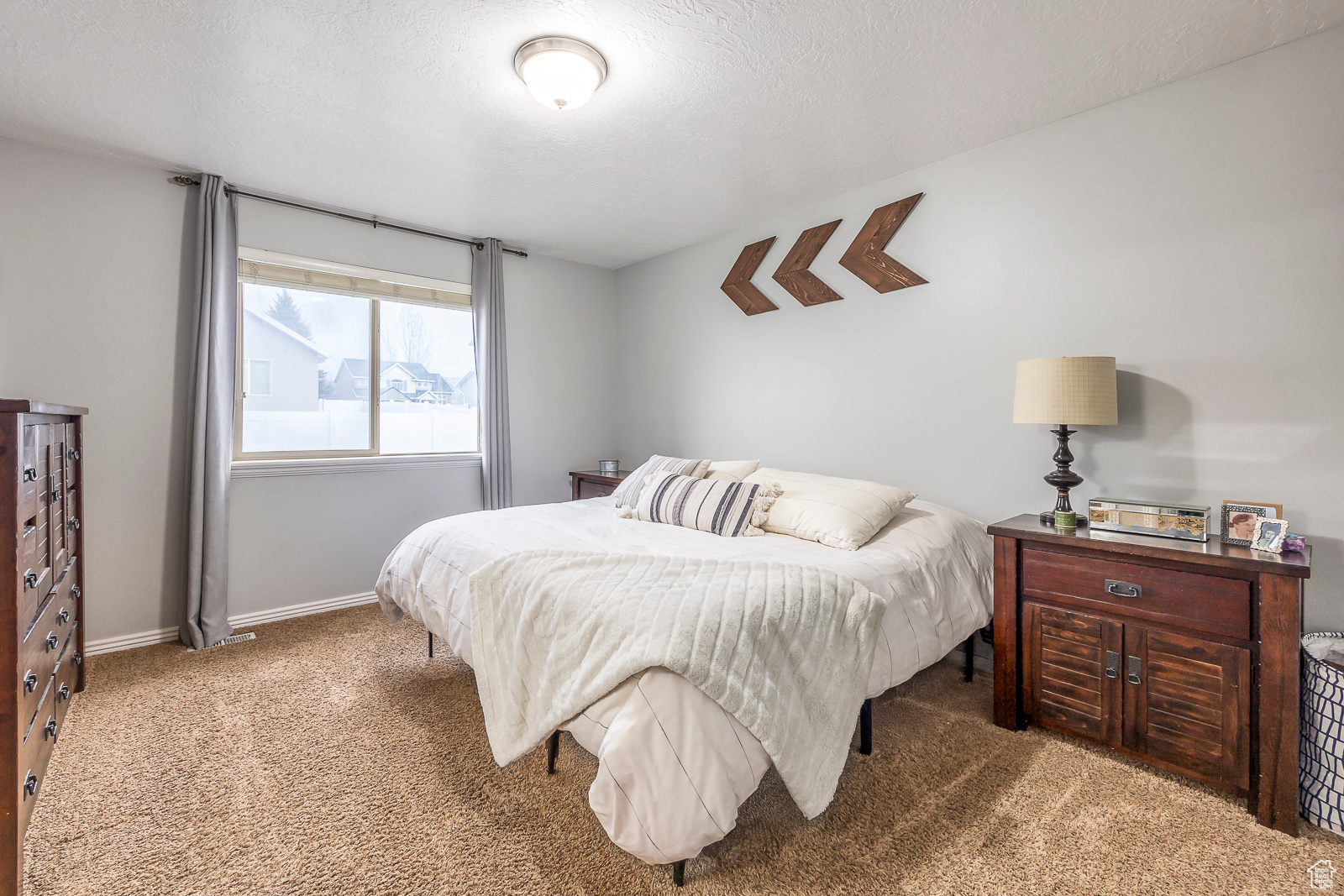 Bedroom with dark carpet and a textured ceiling