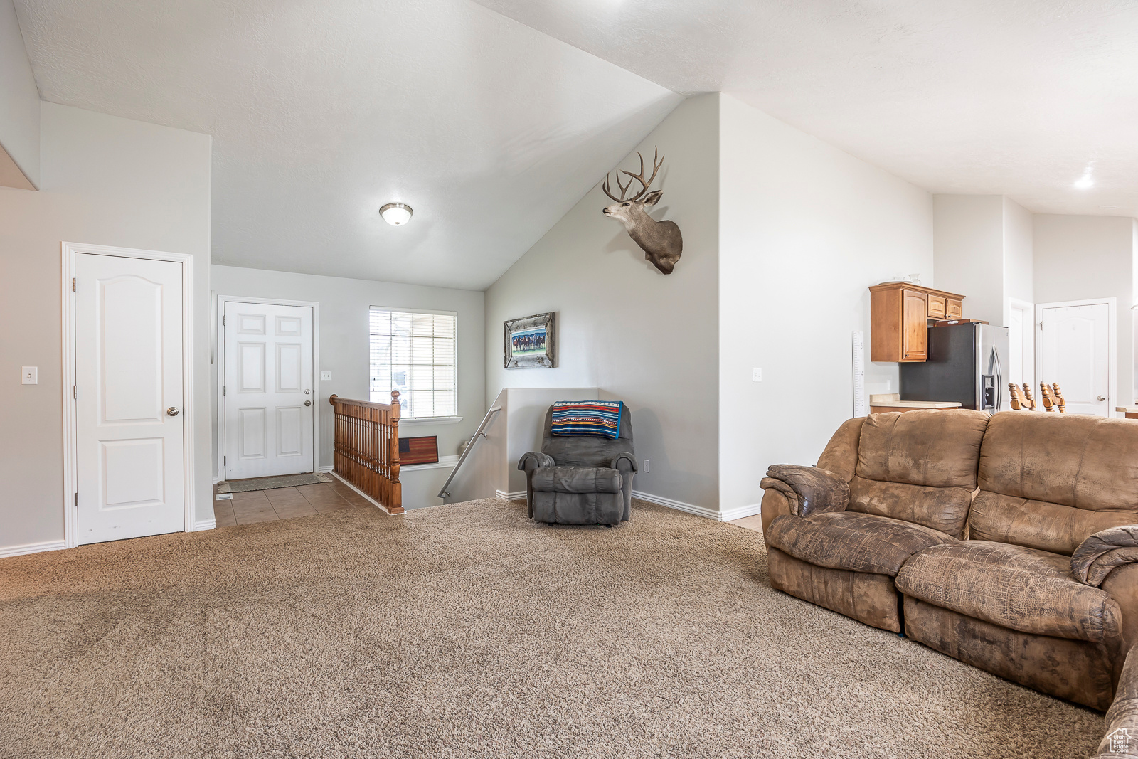 Living room featuring light colored carpet and lofted ceiling