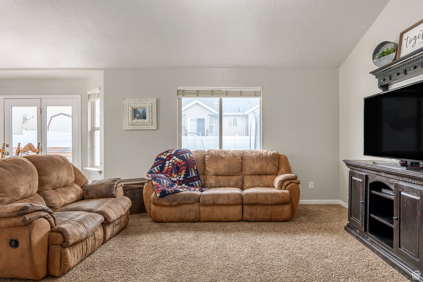 Living room featuring carpet flooring and vaulted ceiling