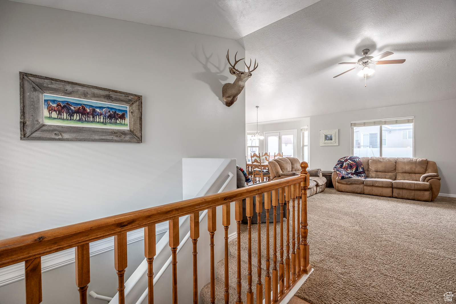 Hallway featuring carpet flooring, a chandelier, and lofted ceiling