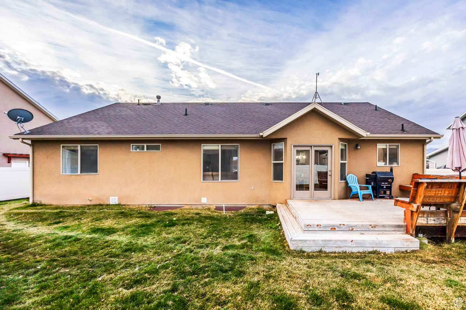 Back of property with a deck and a lawn