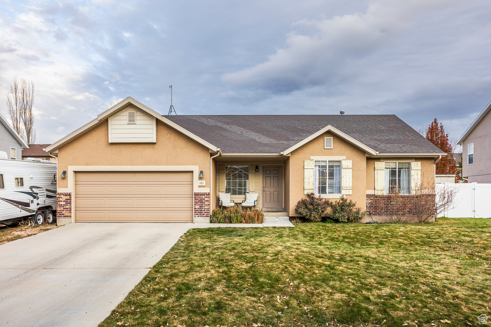 Ranch-style house featuring a front lawn and a garage