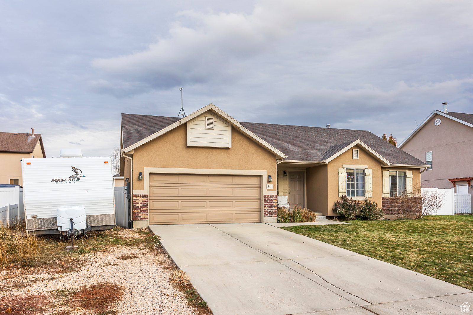 Single story home with a garage and a front lawn