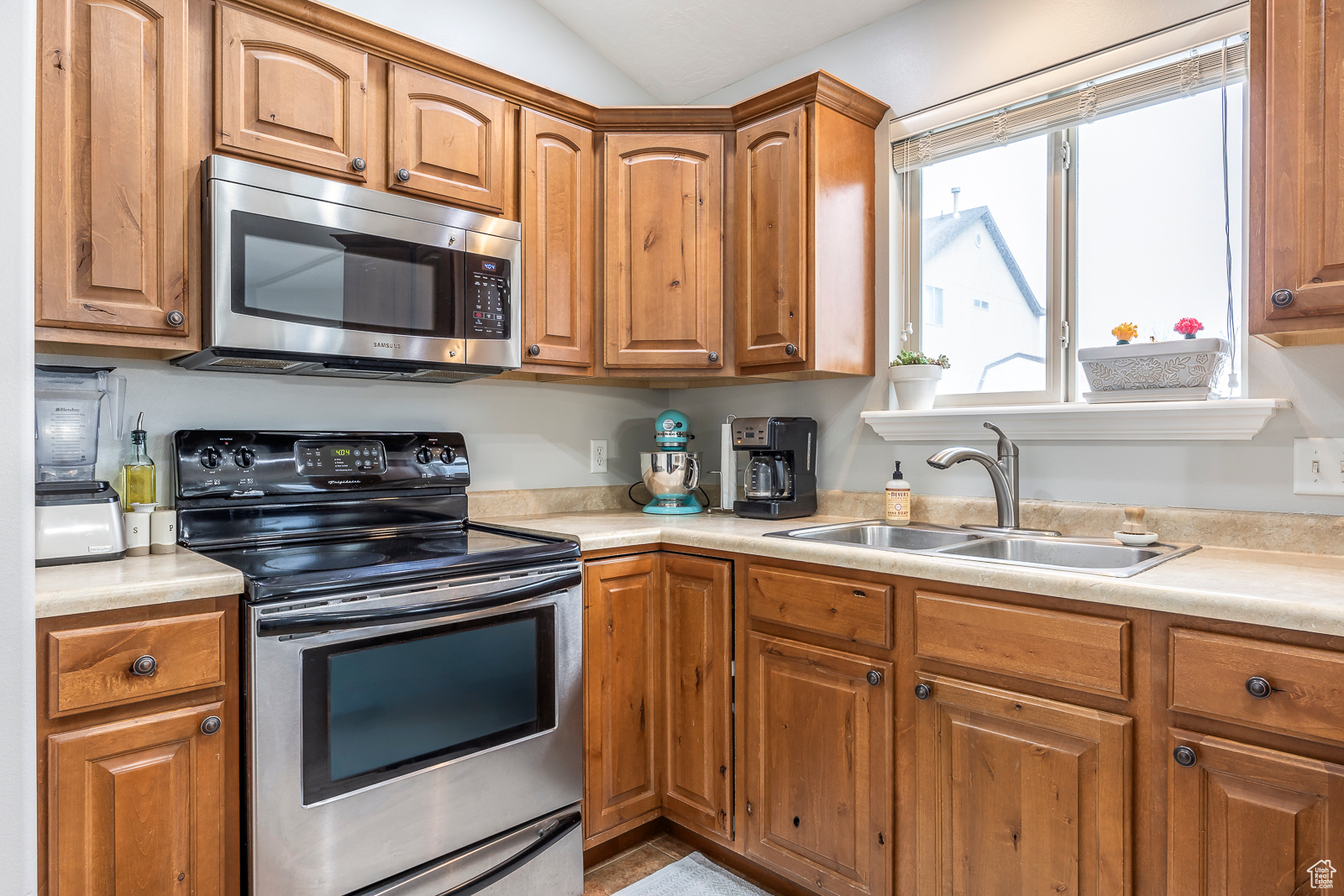 Kitchen featuring lofted ceiling, sink, and appliances with stainless steel finishes