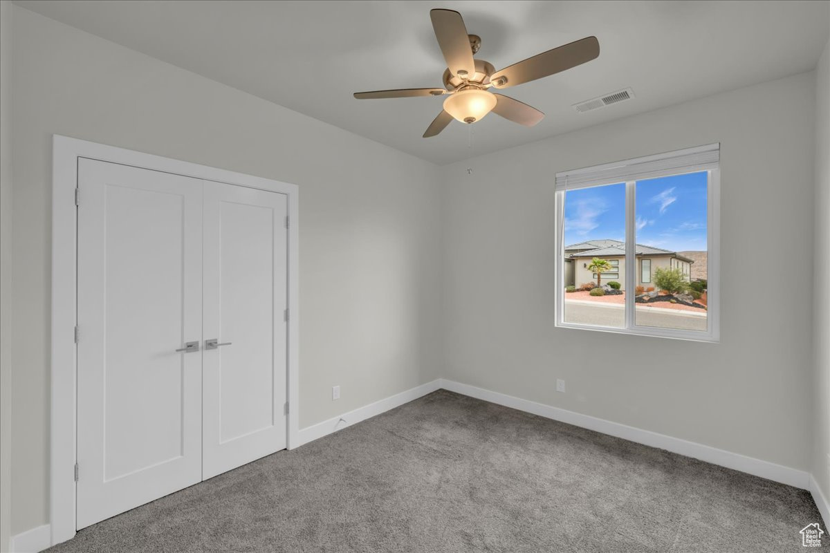 Unfurnished bedroom with light carpet, a closet, and ceiling fan