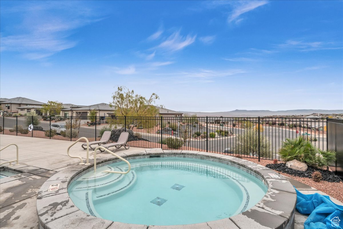 View of pool featuring a mountain view, a community hot tub, and a patio