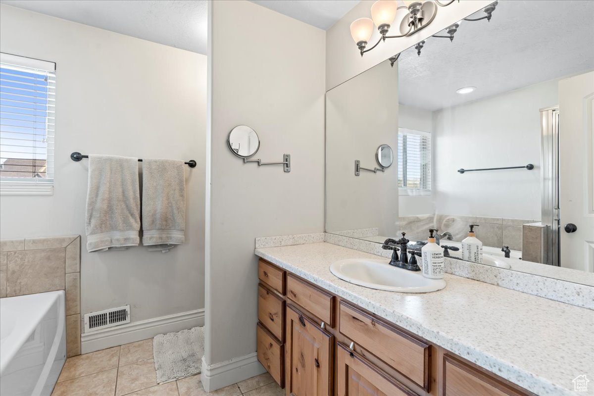 Bathroom featuring tile patterned floors, vanity, and a bathing tub