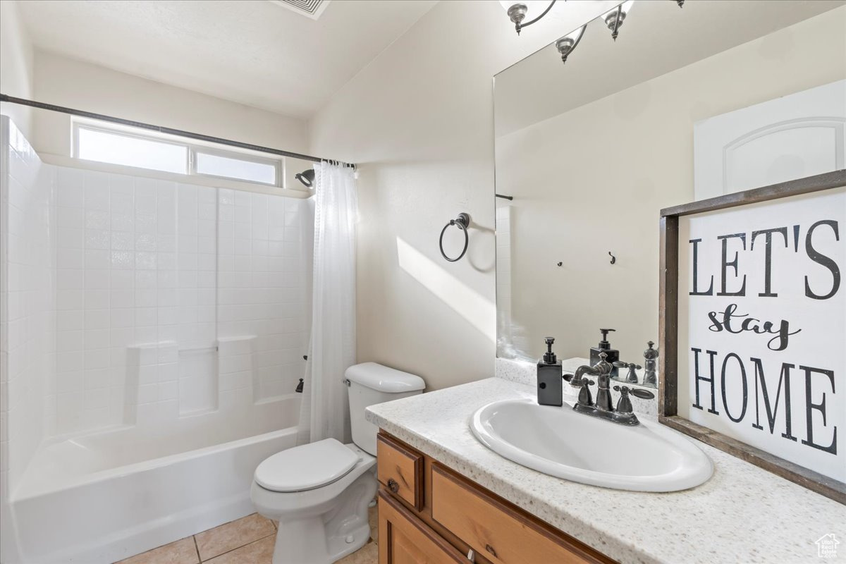 Full bathroom with tile patterned flooring, shower / bath combo, toilet, and vanity