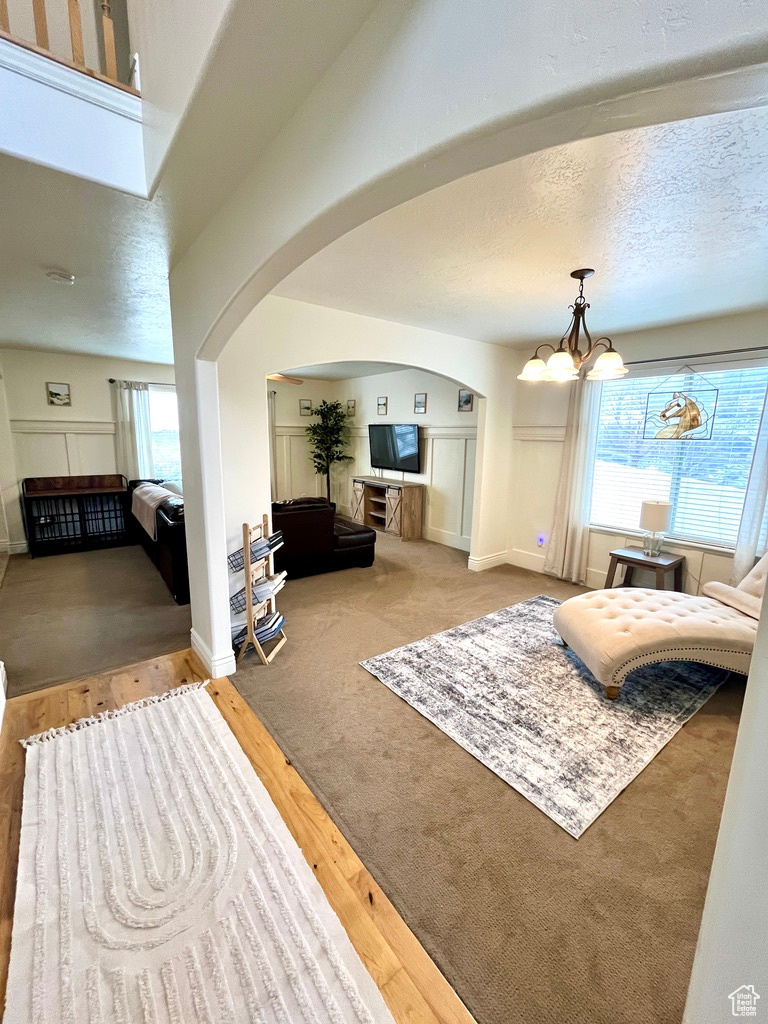 Living room featuring hardwood / wood-style floors, a textured ceiling, and a notable chandelier