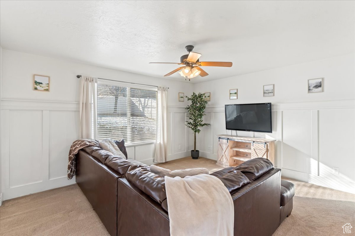 Living room with light carpet and ceiling fan