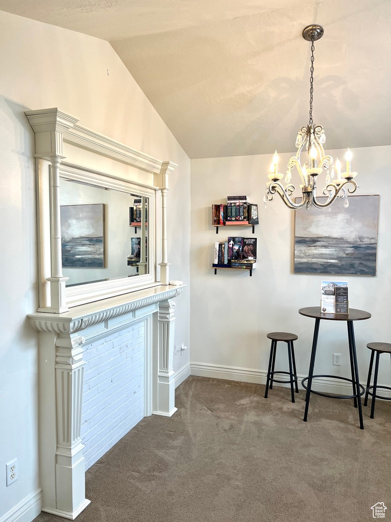 Unfurnished dining area featuring carpet, lofted ceiling, and an inviting chandelier