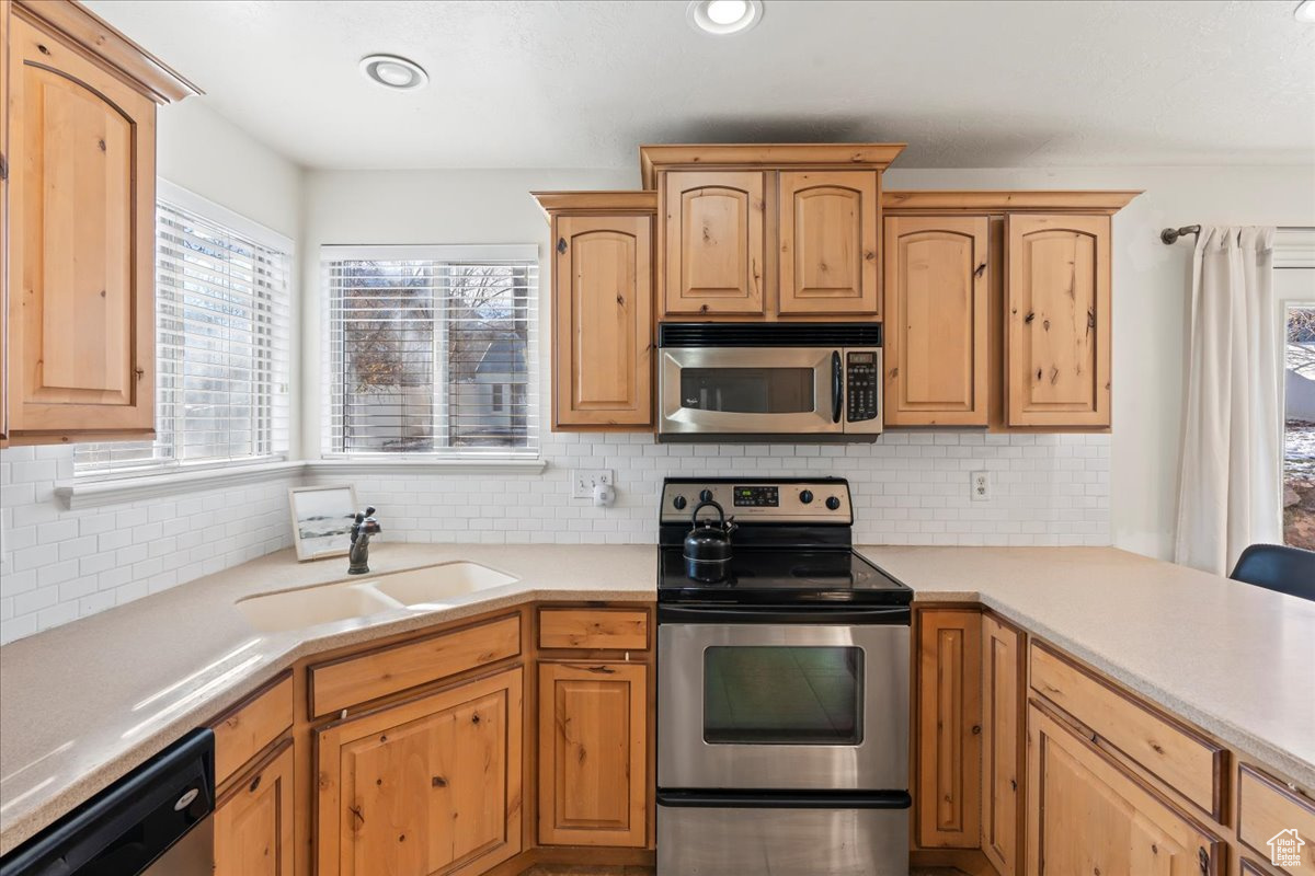 Kitchen featuring tasteful backsplash, sink, and stainless steel appliances