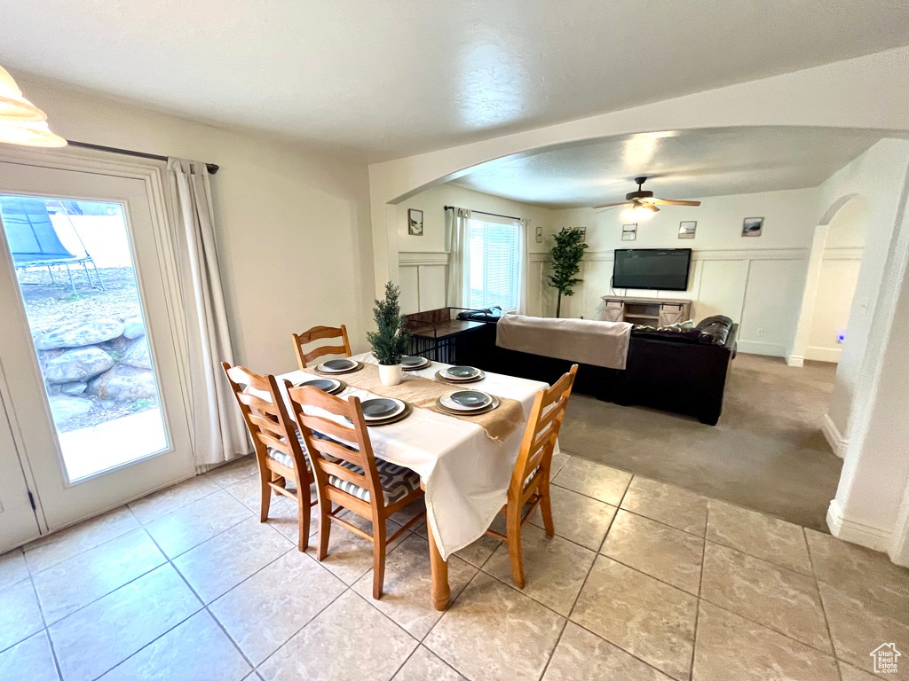 Tiled dining room with ceiling fan and plenty of natural light