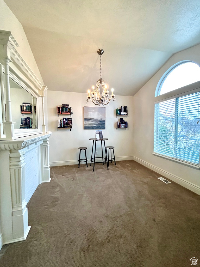 Unfurnished dining area with carpet, a chandelier, and vaulted ceiling