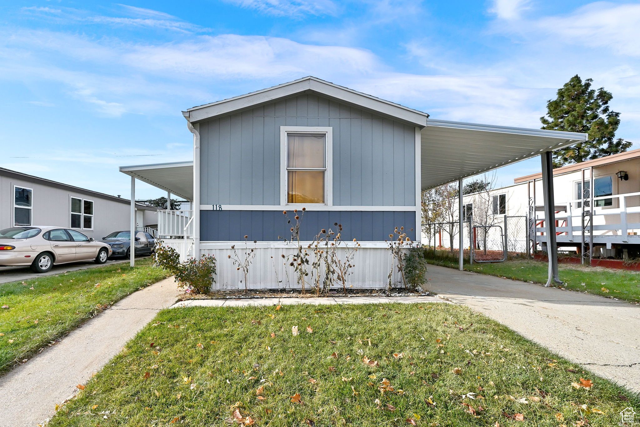 View of side of home with a lawn and a carport