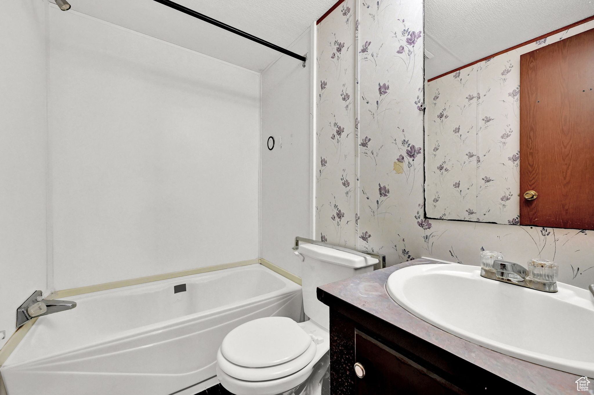 Full bathroom featuring vanity, a textured ceiling, shower / bath combination, and toilet