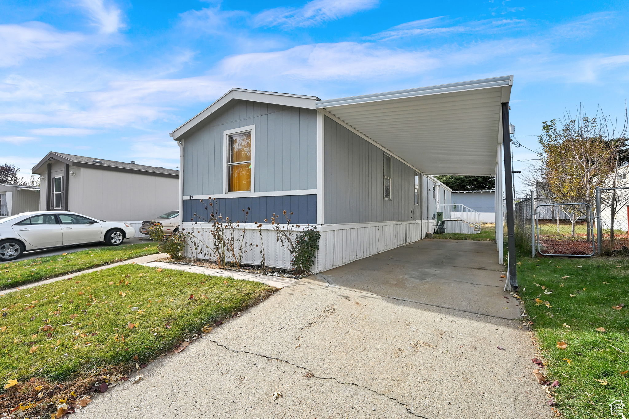 View of property exterior featuring a lawn and a carport