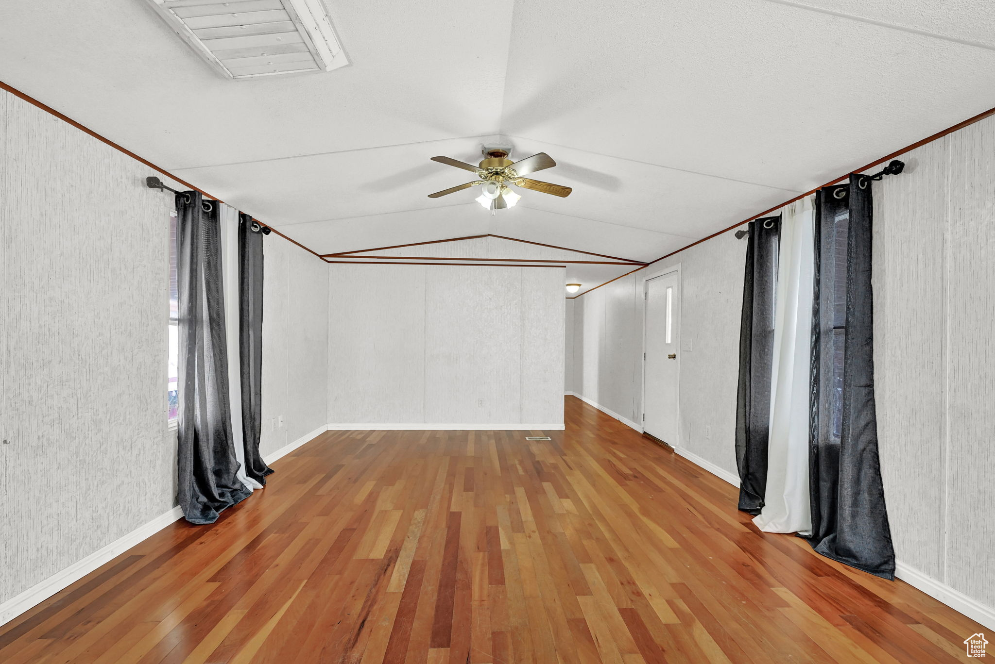 Unfurnished room featuring ceiling fan, hardwood / wood-style floors, lofted ceiling, and ornamental molding