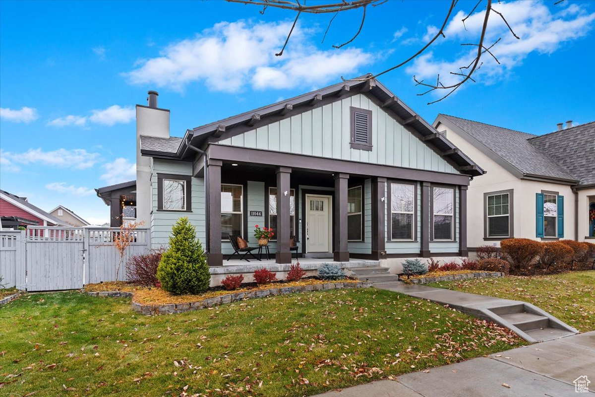 View of front of property with a front yard and a covered porch