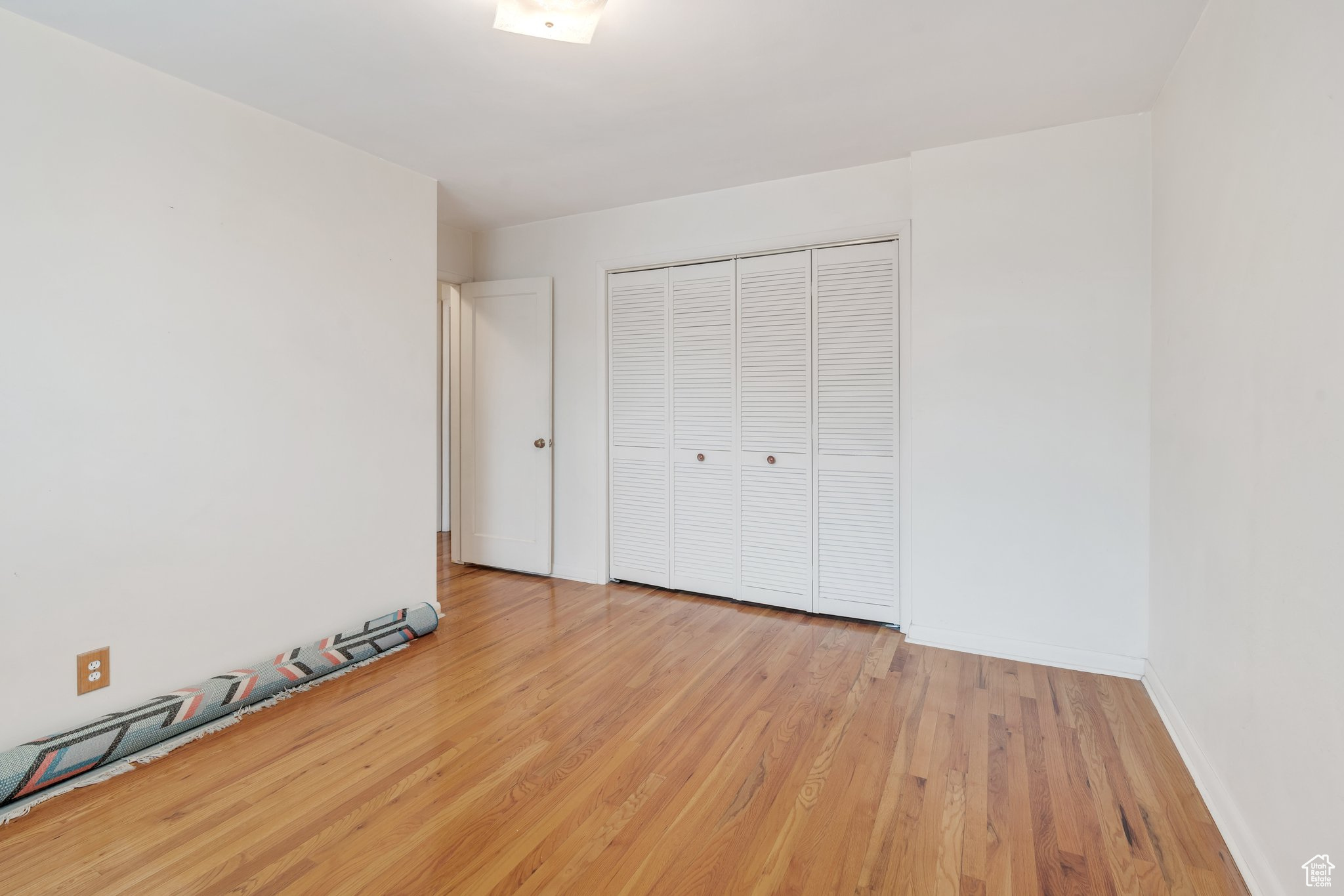 Unfurnished bedroom with light hardwood / wood-style flooring and a closet