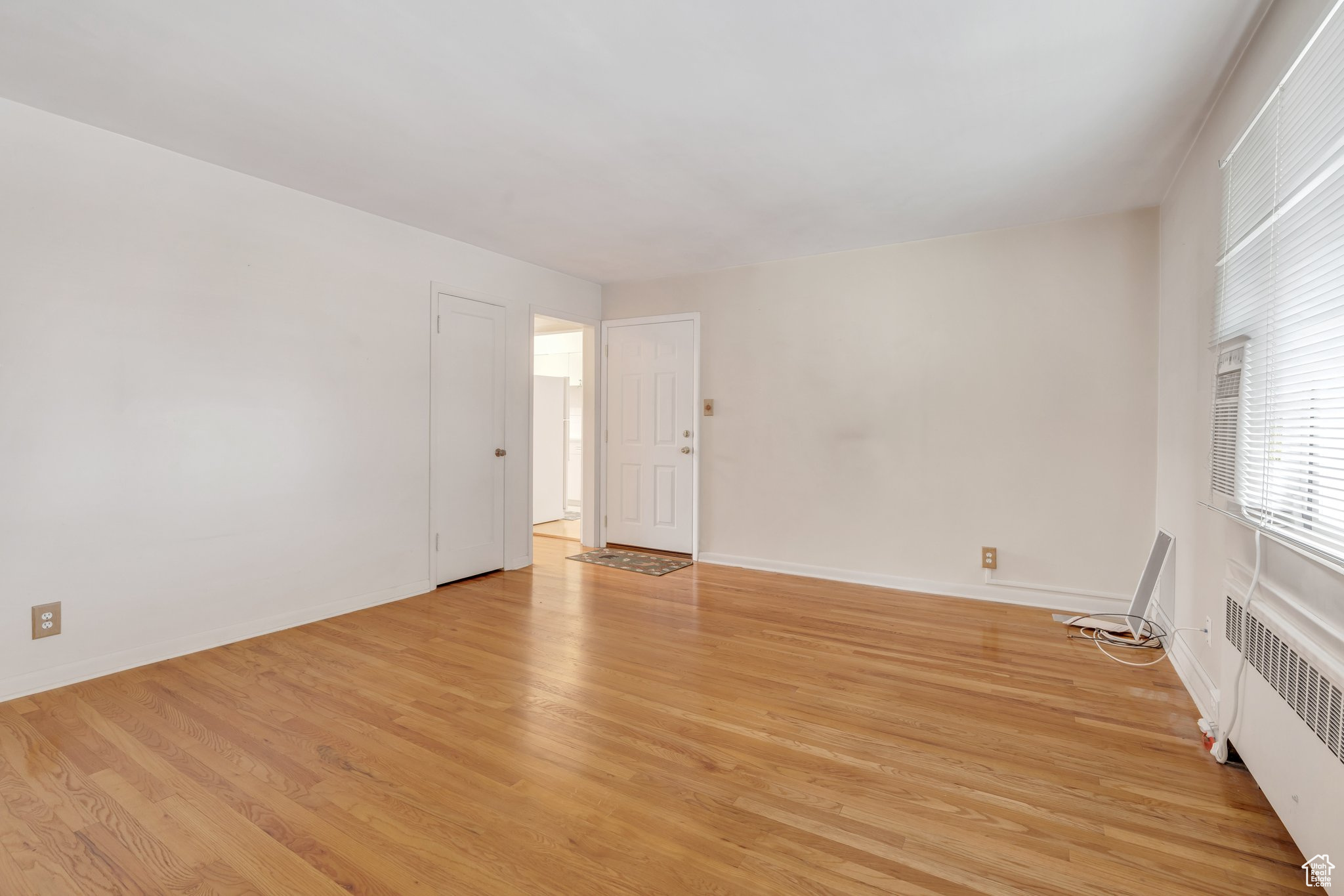 Spare room featuring radiator heating unit and light hardwood / wood-style floors