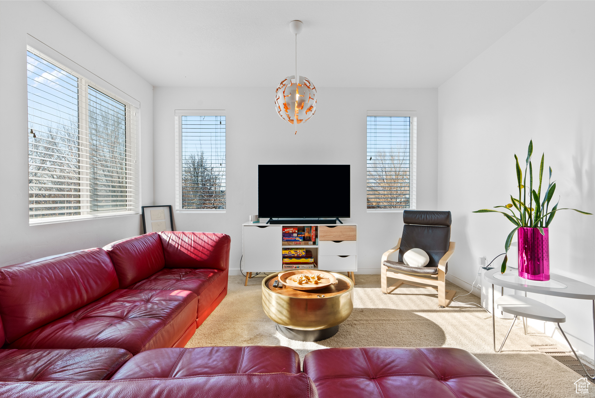 Carpeted living room with an inviting chandelier