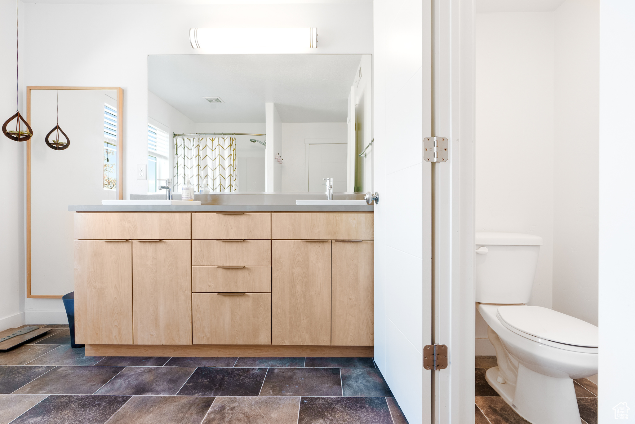 Bathroom with a shower with curtain, vanity, and toilet