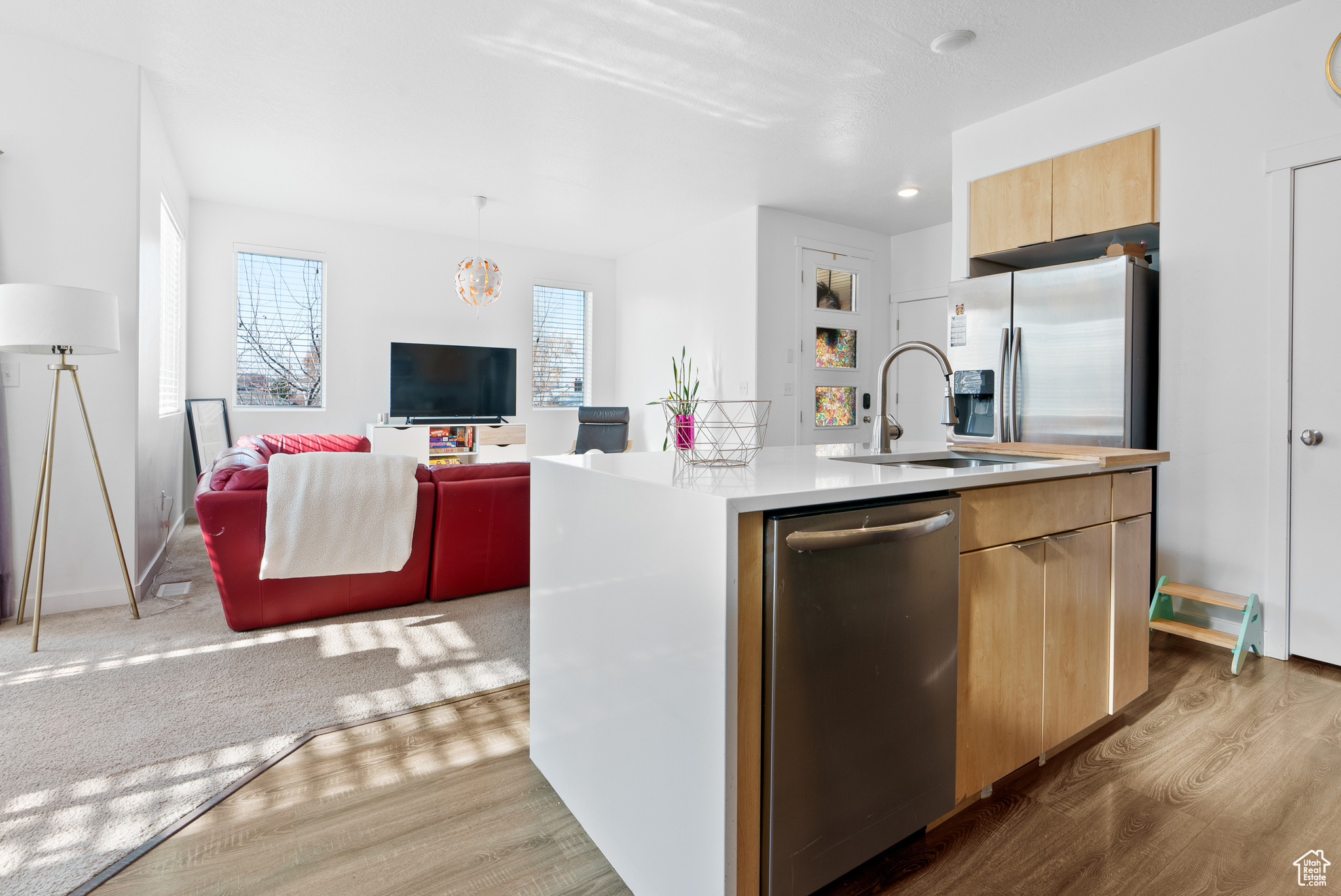 Kitchen featuring appliances with stainless steel finishes, a center island with sink, light hardwood / wood-style floors, and sink