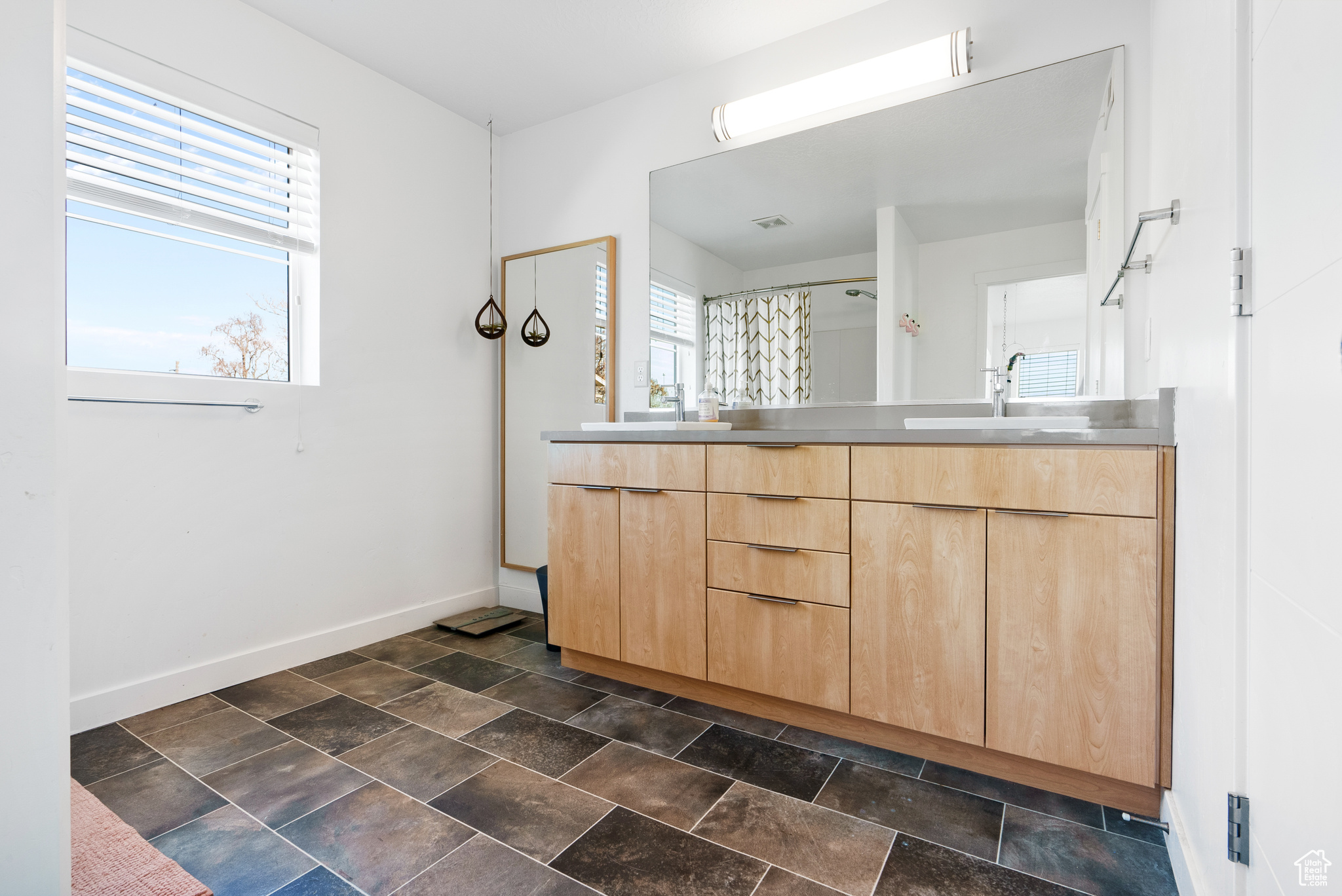 Bathroom with a shower with shower curtain and vanity