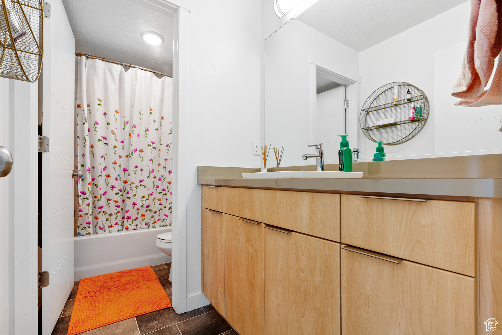 Full bathroom with tile patterned floors, vanity, toilet, and shower / bathtub combination with curtain