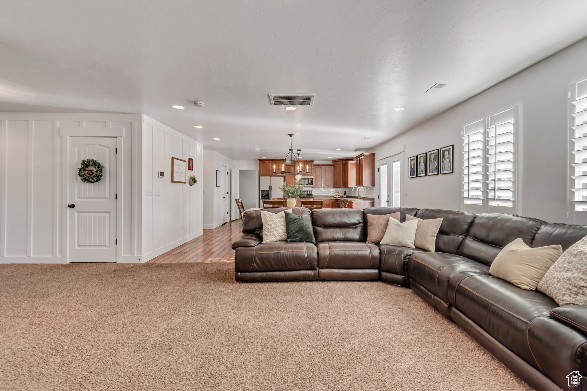 Living room featuring light carpet and an inviting chandelier