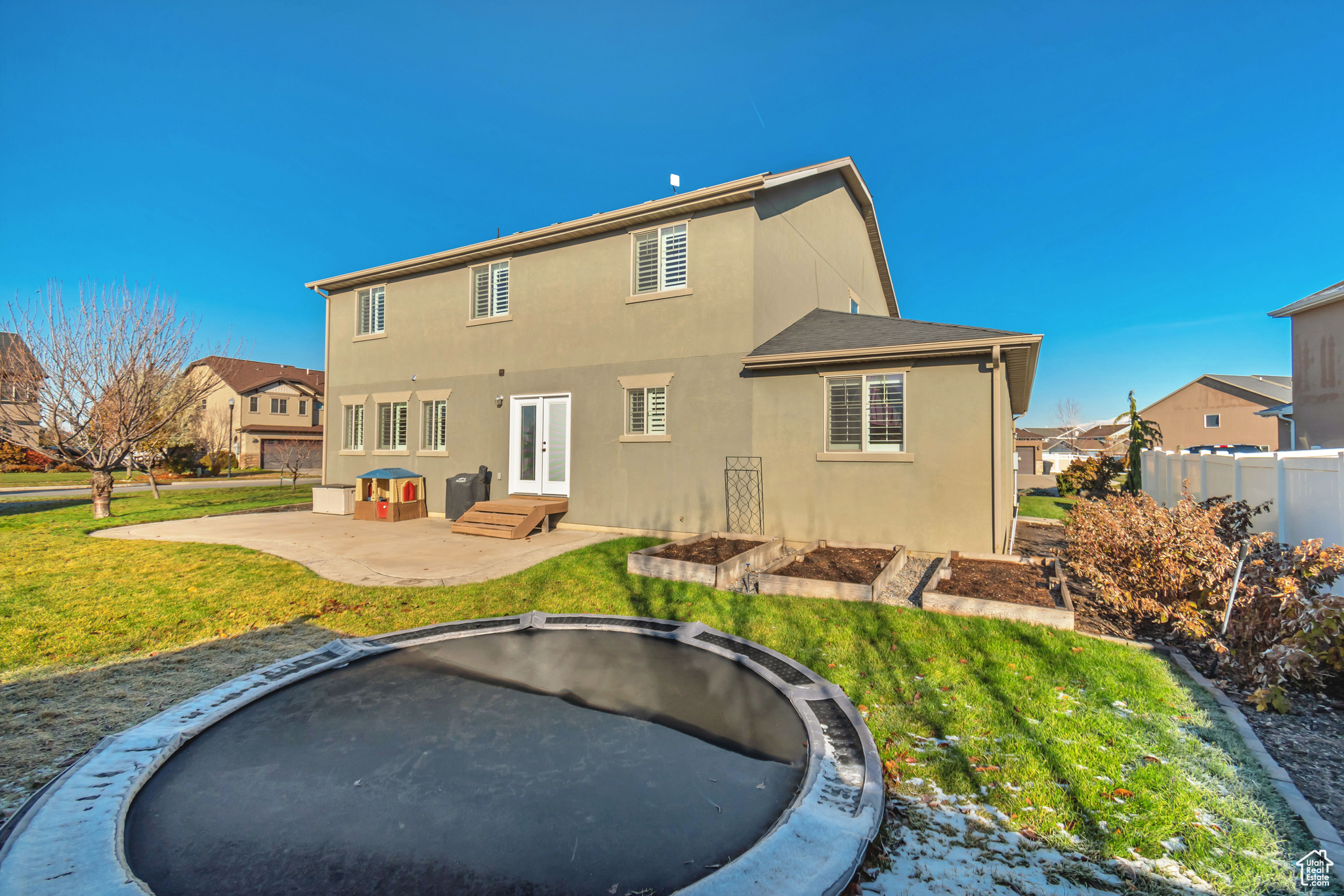 Back of house with french doors, a yard, a trampoline, and a patio area