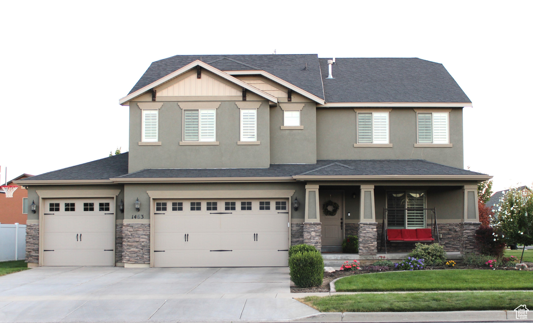 View of front facade featuring a front yard, a porch, and a garage