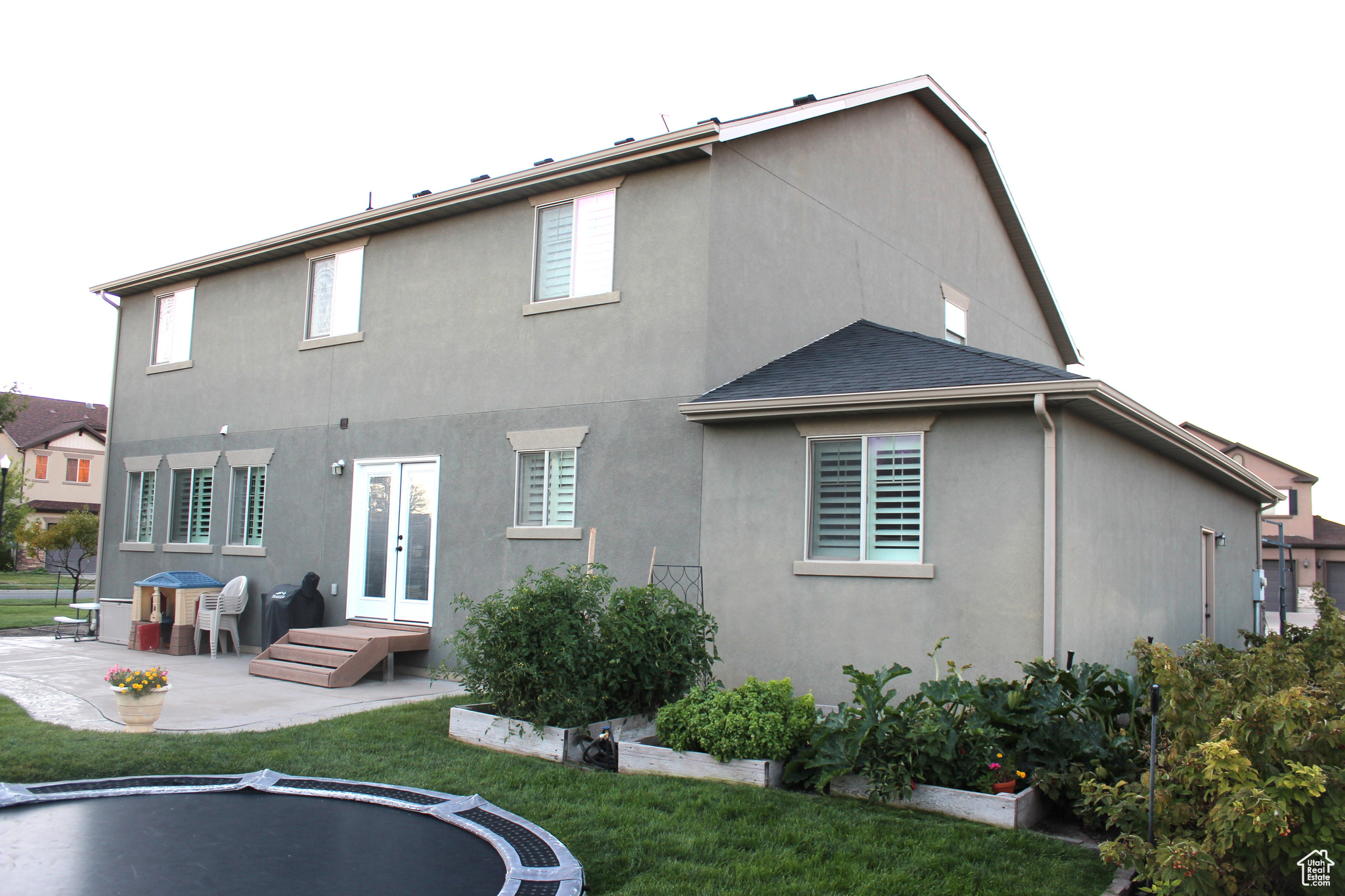 Rear view of property with a lawn, french doors, and a patio