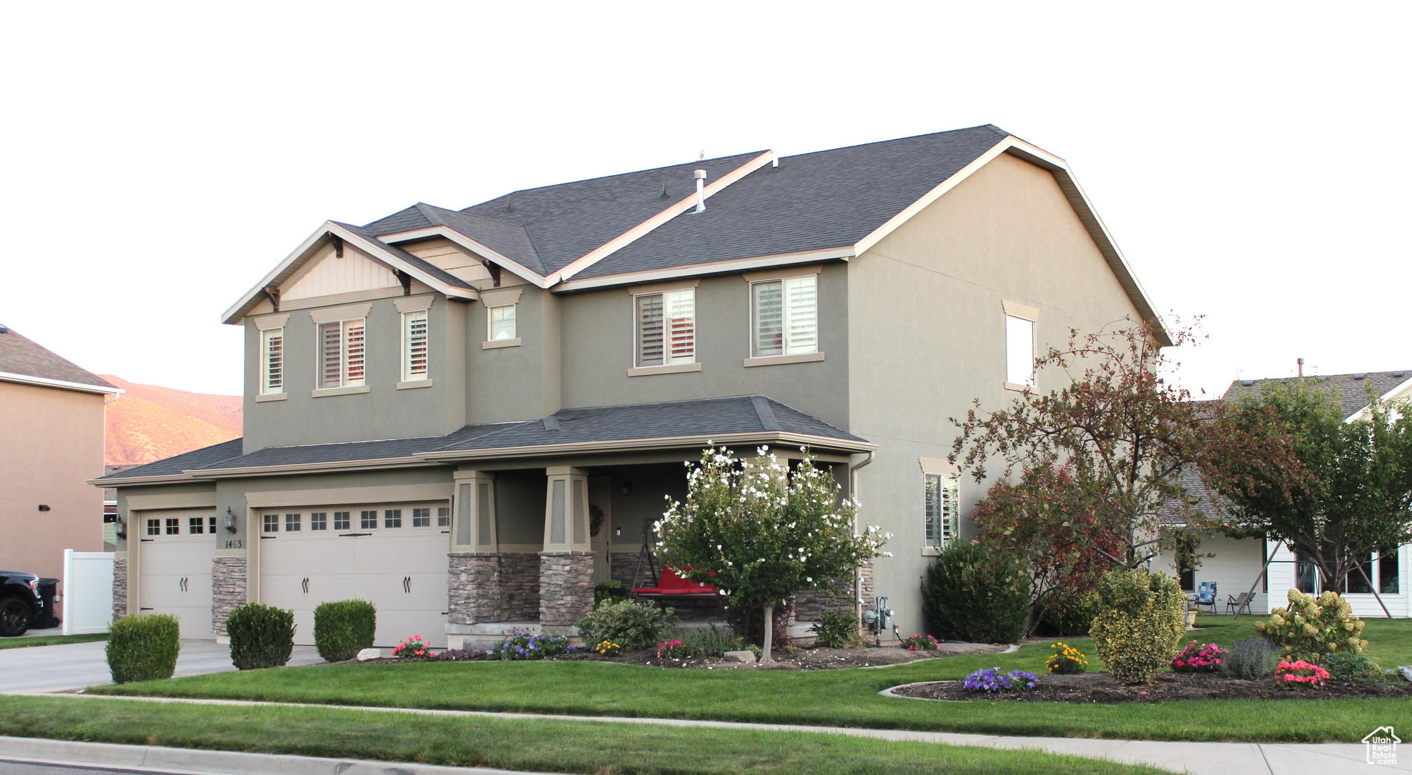 View of front facade featuring a garage and a front lawn