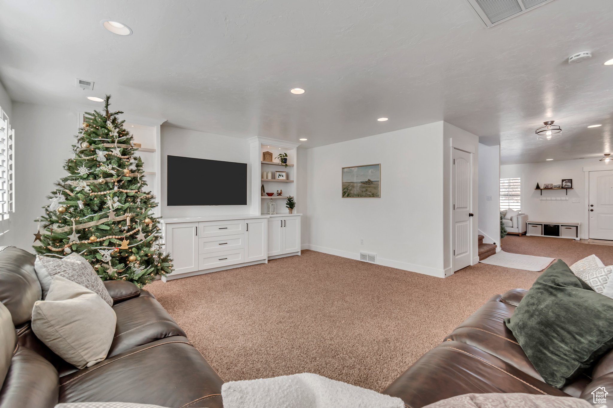 Carpeted living room with built in shelves