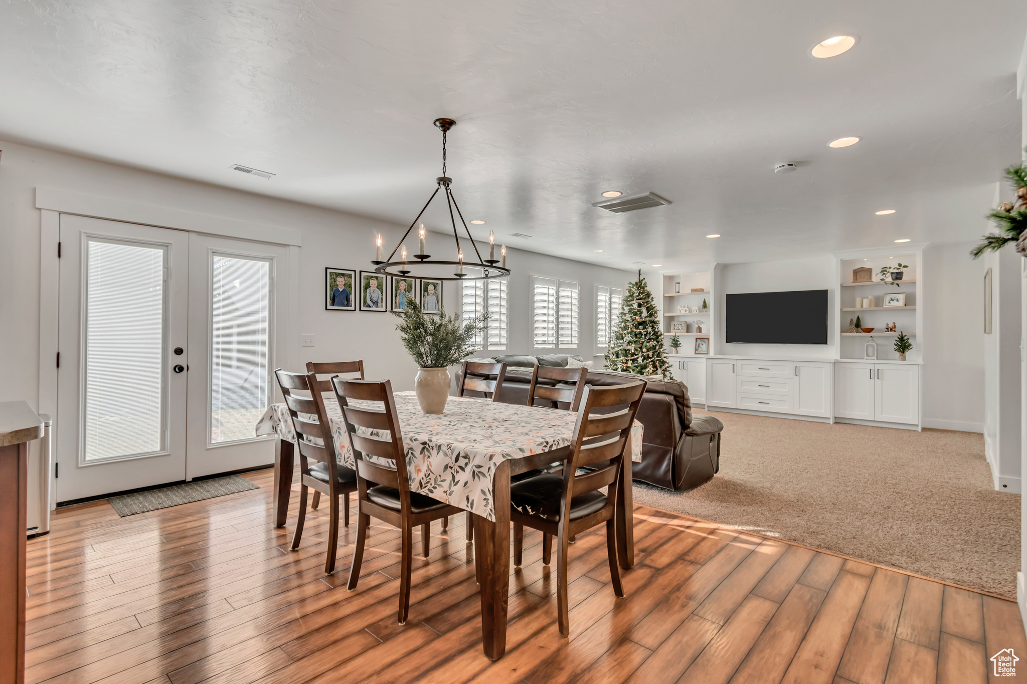 Dining area featuring french doors, built in features, a notable chandelier, and light hardwood / wood-style flooring