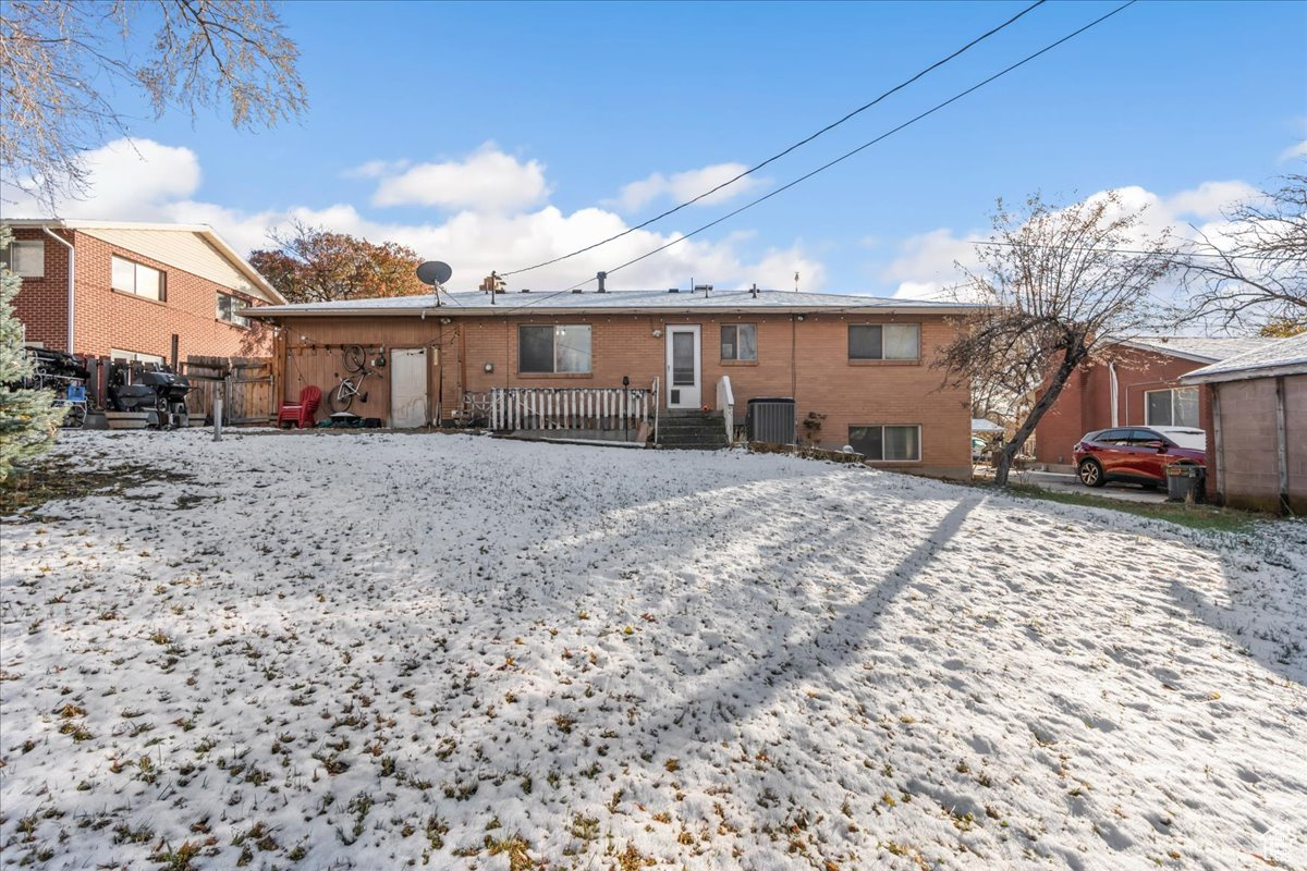 Snow covered house featuring central AC unit