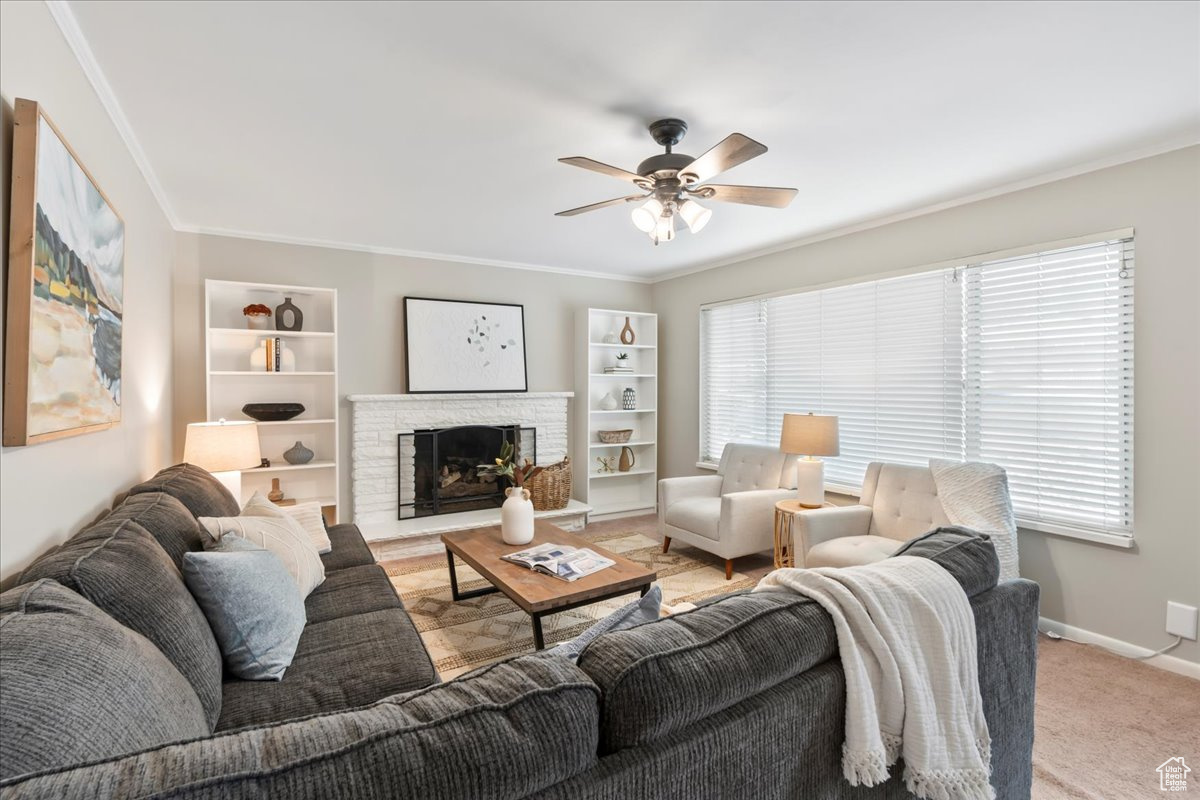 Living room featuring a fireplace, a wealth of natural light, and ornamental molding