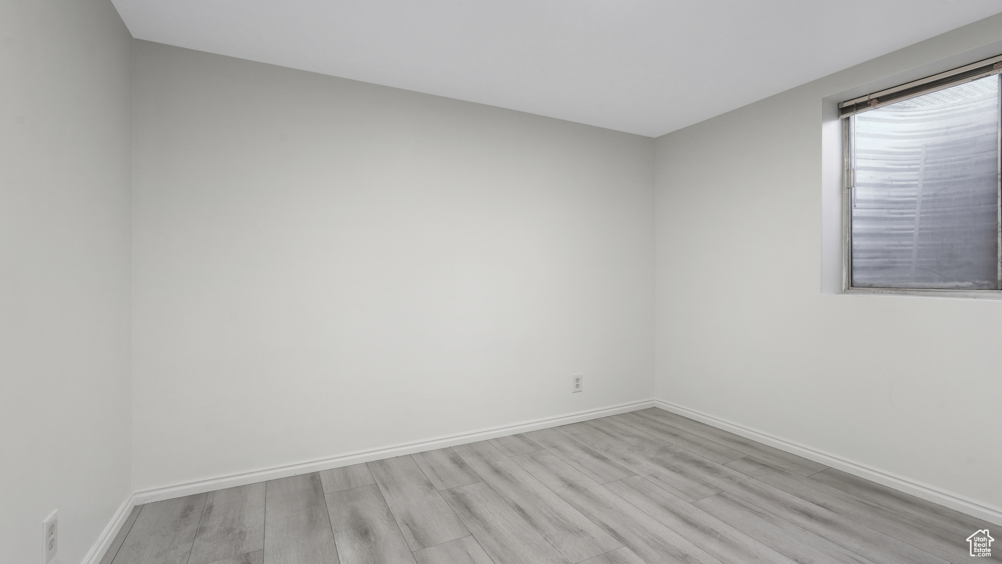 Basement bedroom with light wood-type flooring