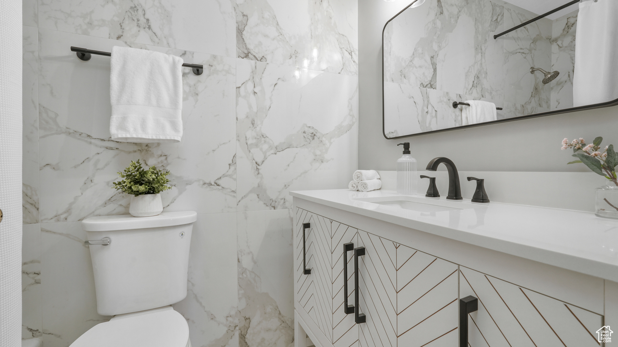 Bathroom with walk in shower, vanity, tile walls, and toilet