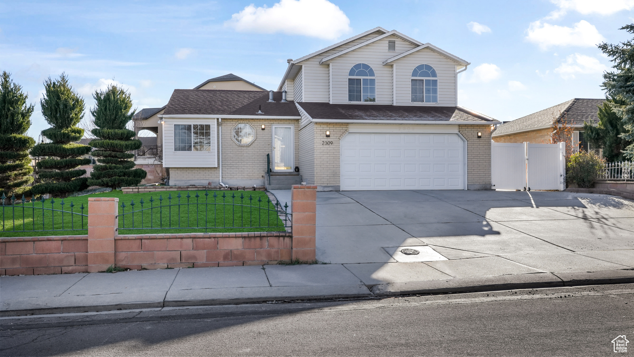 View of front of home with a garage and a front lawn