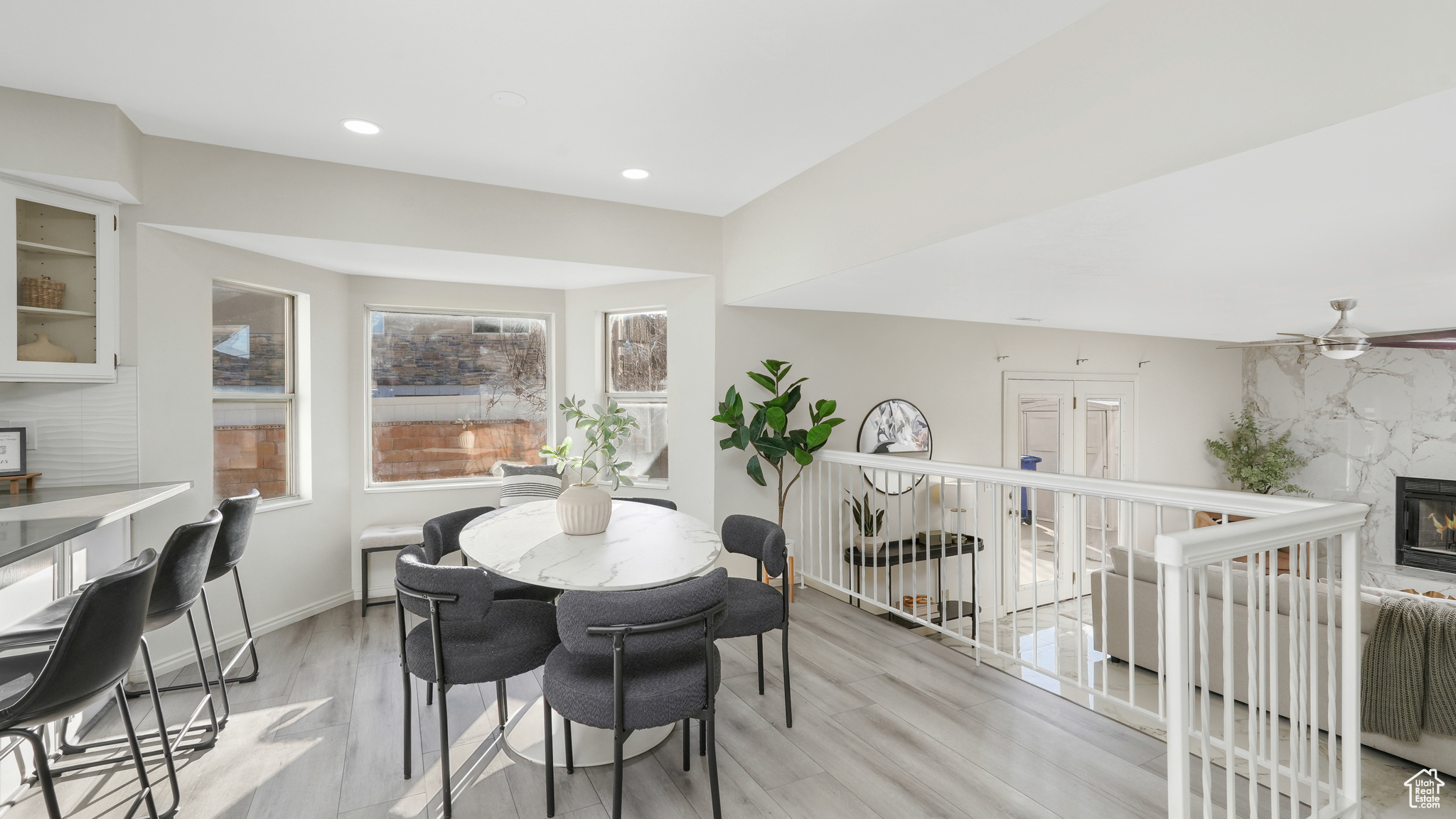 Dining area featuring ceiling fan, a fireplace, and light hardwood / wood-style flooring